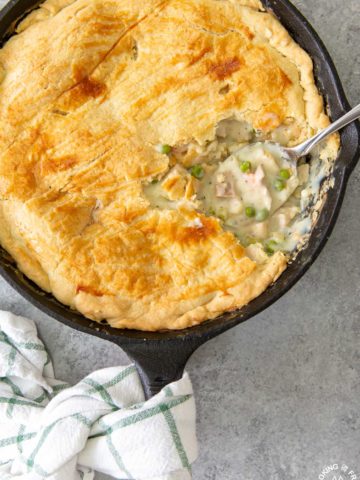 chicken pot pie in a skillet with a serving spoon