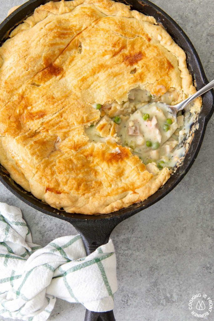 chicken pot pie in a skillet with a serving spoon