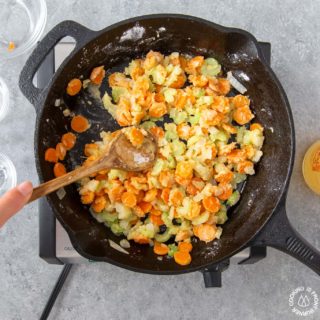 stirring veggies with flour in a skillet for chicken pot pie