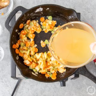 adding chicken broth to a skillet to make chicken pot pie