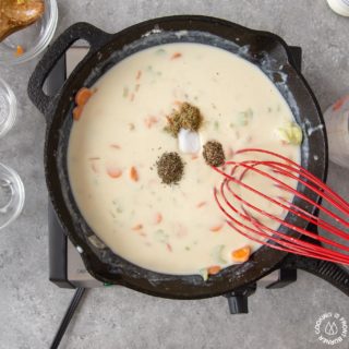 adding spices to the chicken pot pie