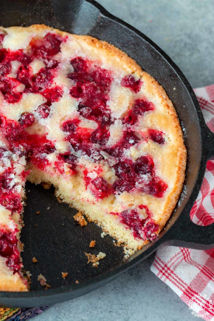 cranberry skillet bread with a slice out of the skillet