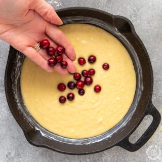 placing fresh cranberries on batter