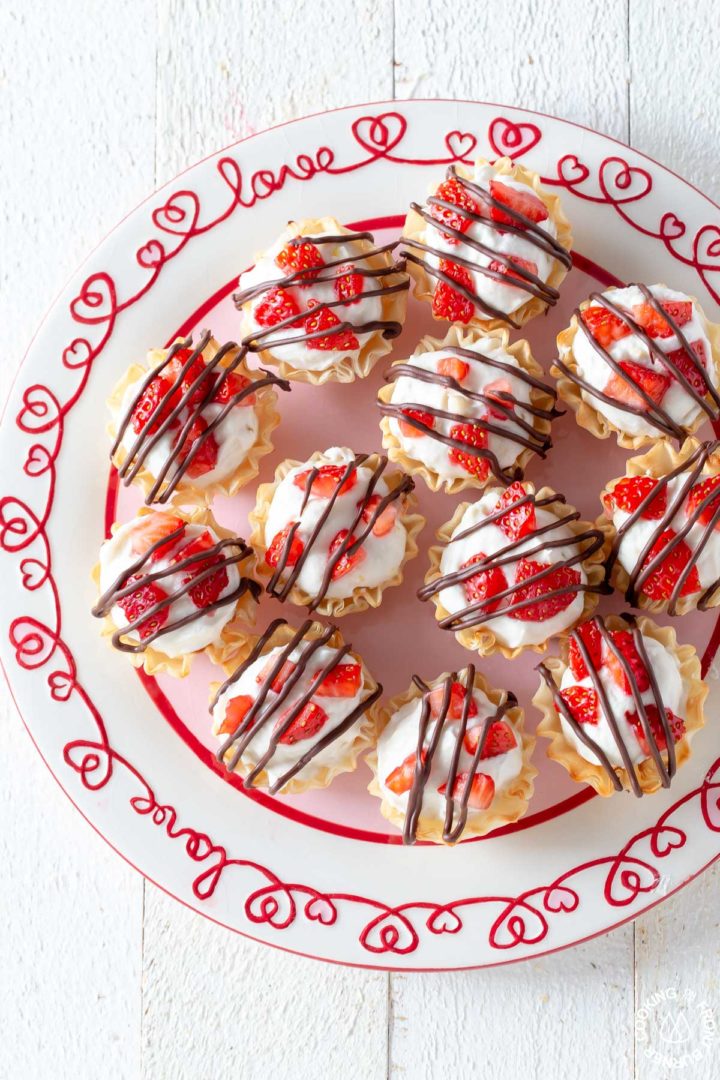 several strawberry cheesecake phyllo cups on a plate