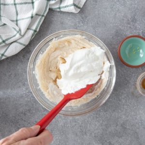 stirring whipped cream into a cream cheese mixture