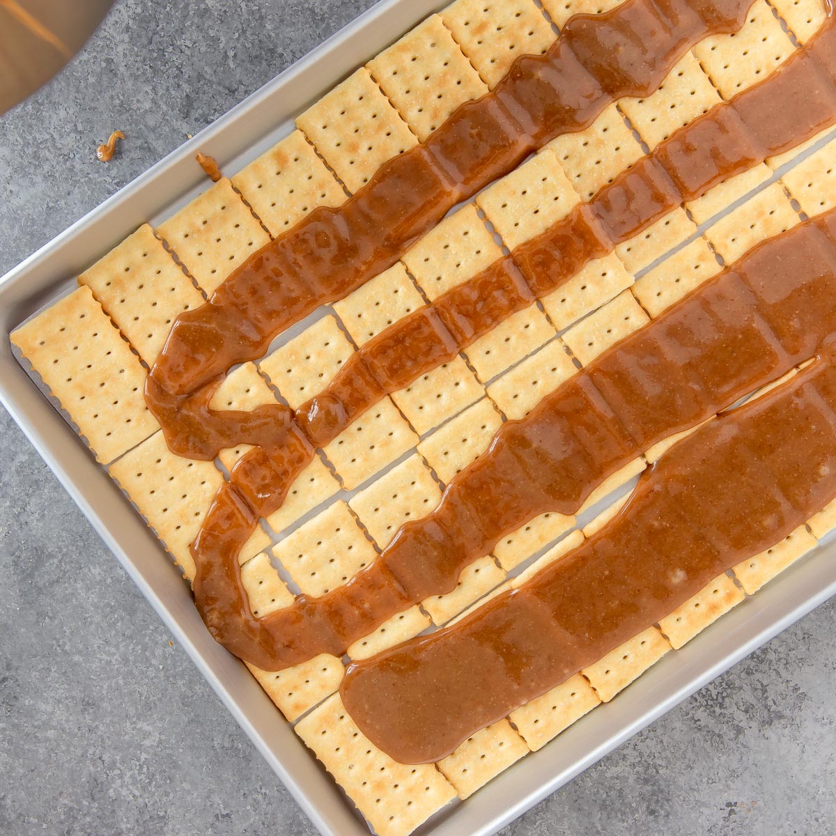 spreading toffee mixture on top of crackers