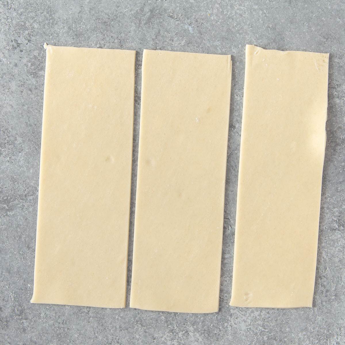 cutting a square piece of pie crust into 3 equal strips