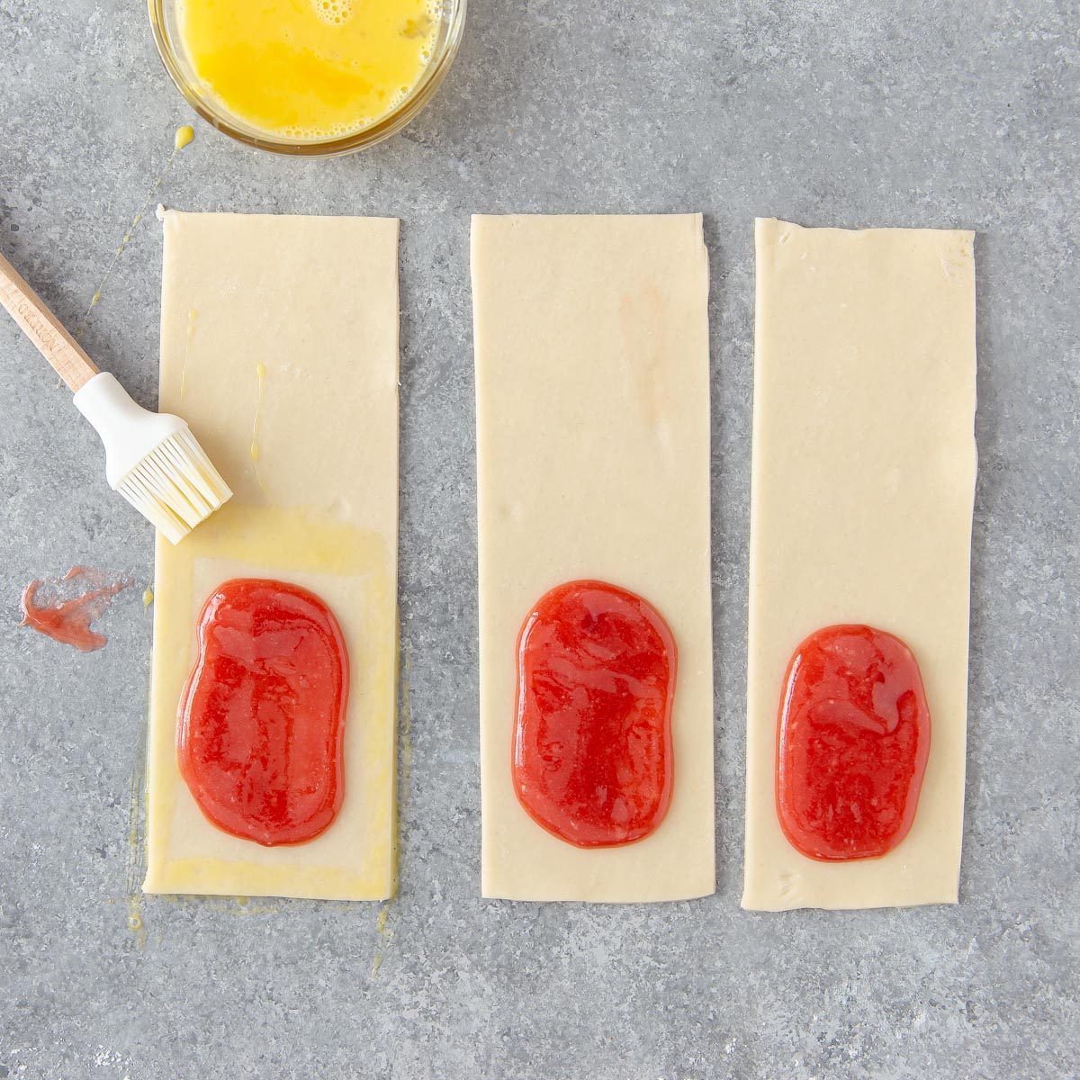 brushing a beaten egg around edges of pie crust