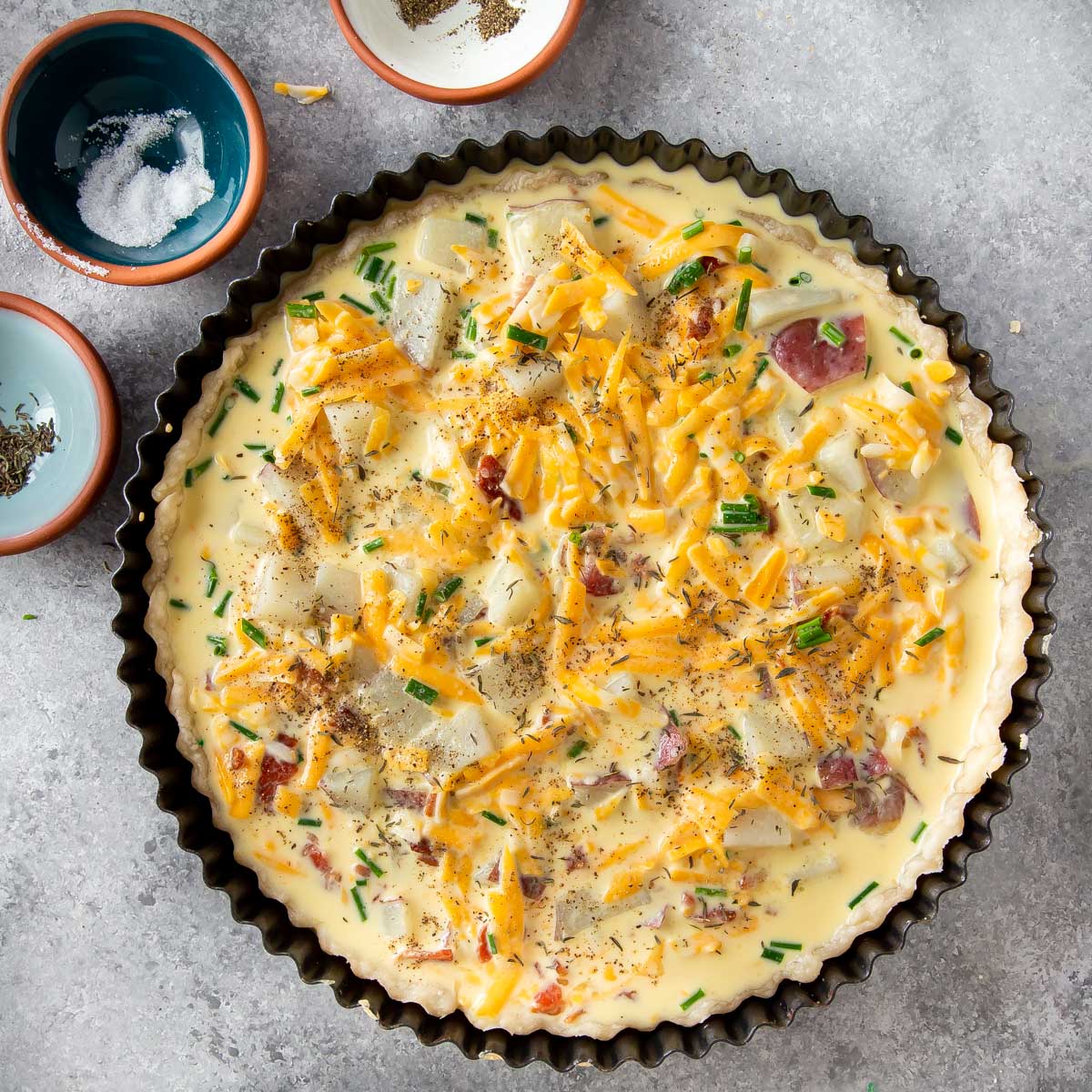 quiche mixture poured in a quiche tart pan with crust