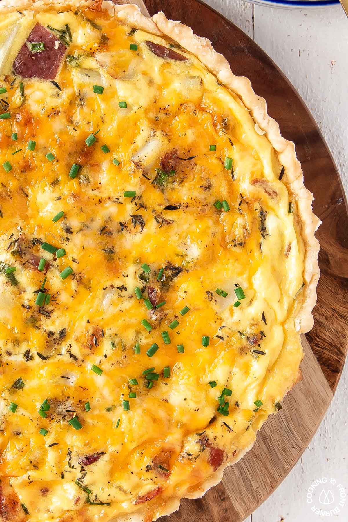 a close up picture of loaded baked potato quiche on a serving board