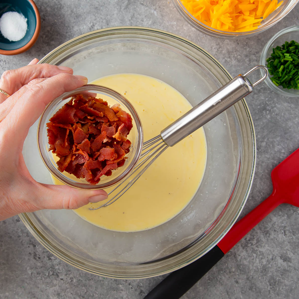 adding cooked bacon to quiche mixture