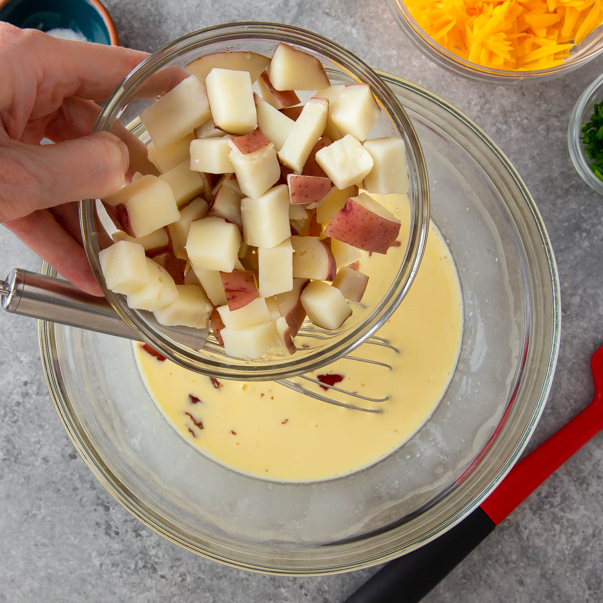 adding cooked potatoes to quiche mixture