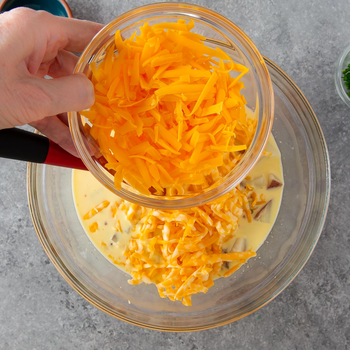 adding cheddar cheese to quiche mixture