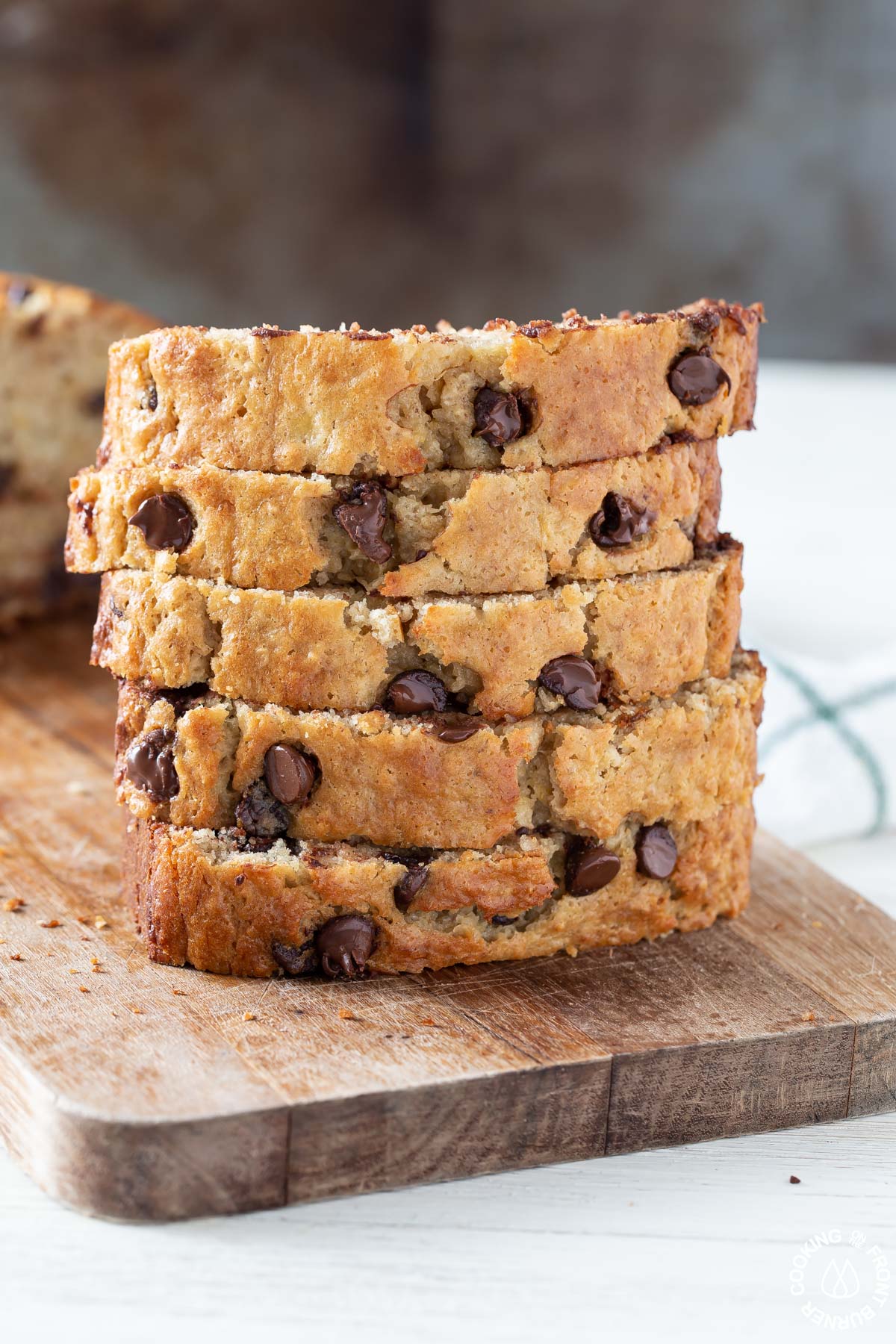 5 slices of chocolate chip banana bread stacked on a board