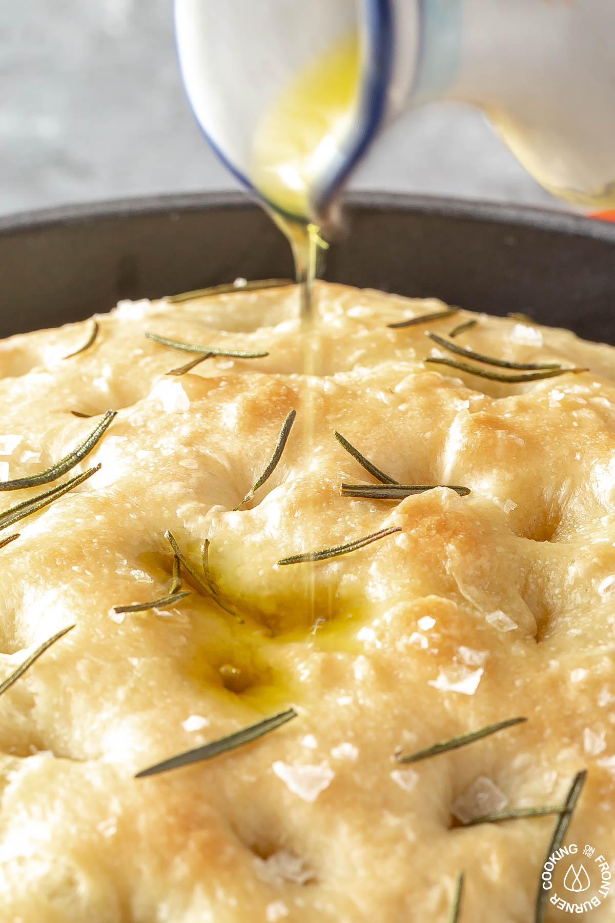 drizzling olive oil on focaccia bread