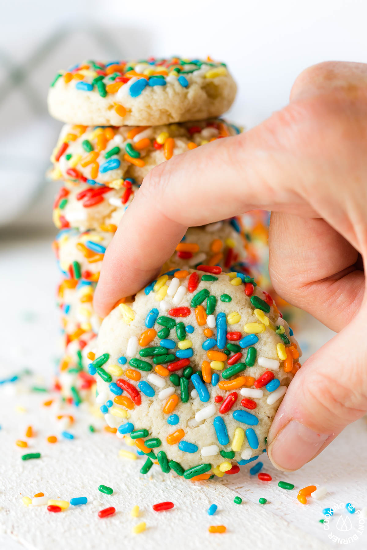 A chewy sprinkle cookie in a hand