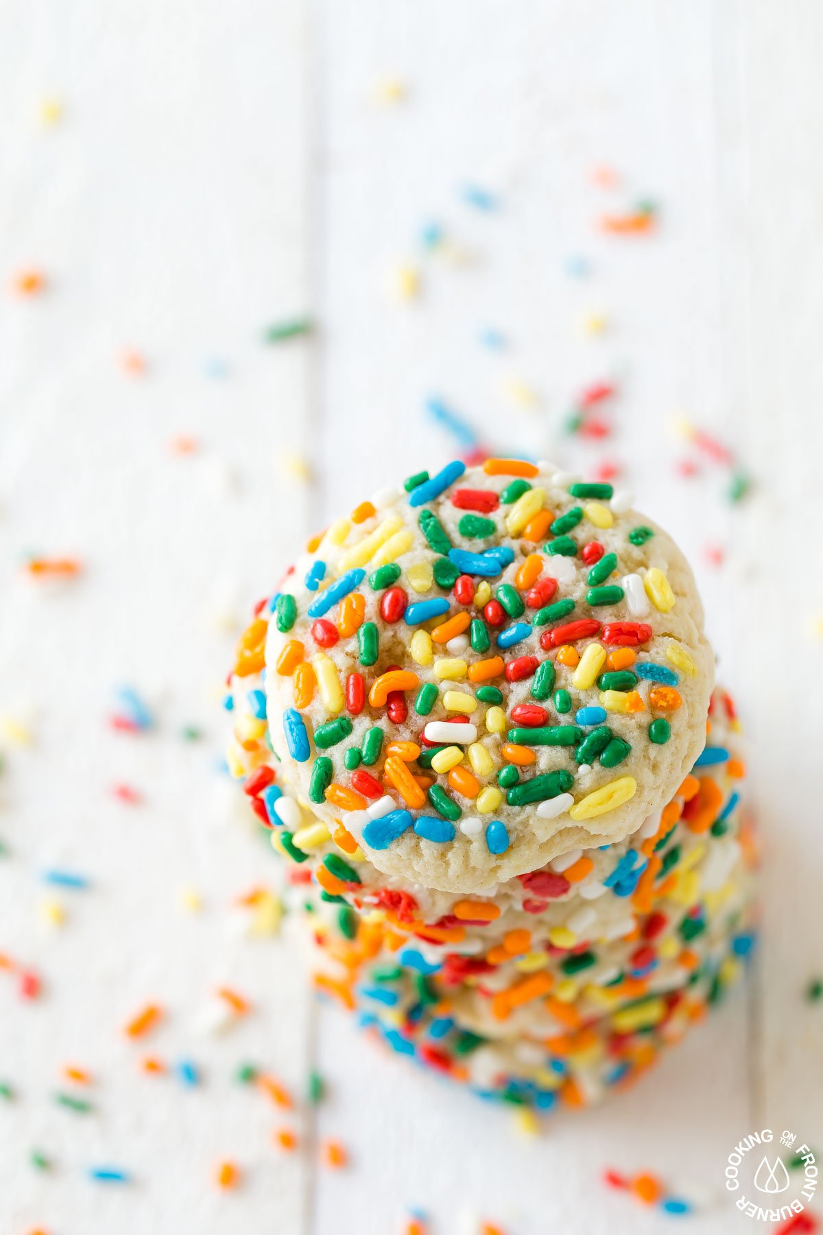 A stack of chewy sprinkle cookies on a board