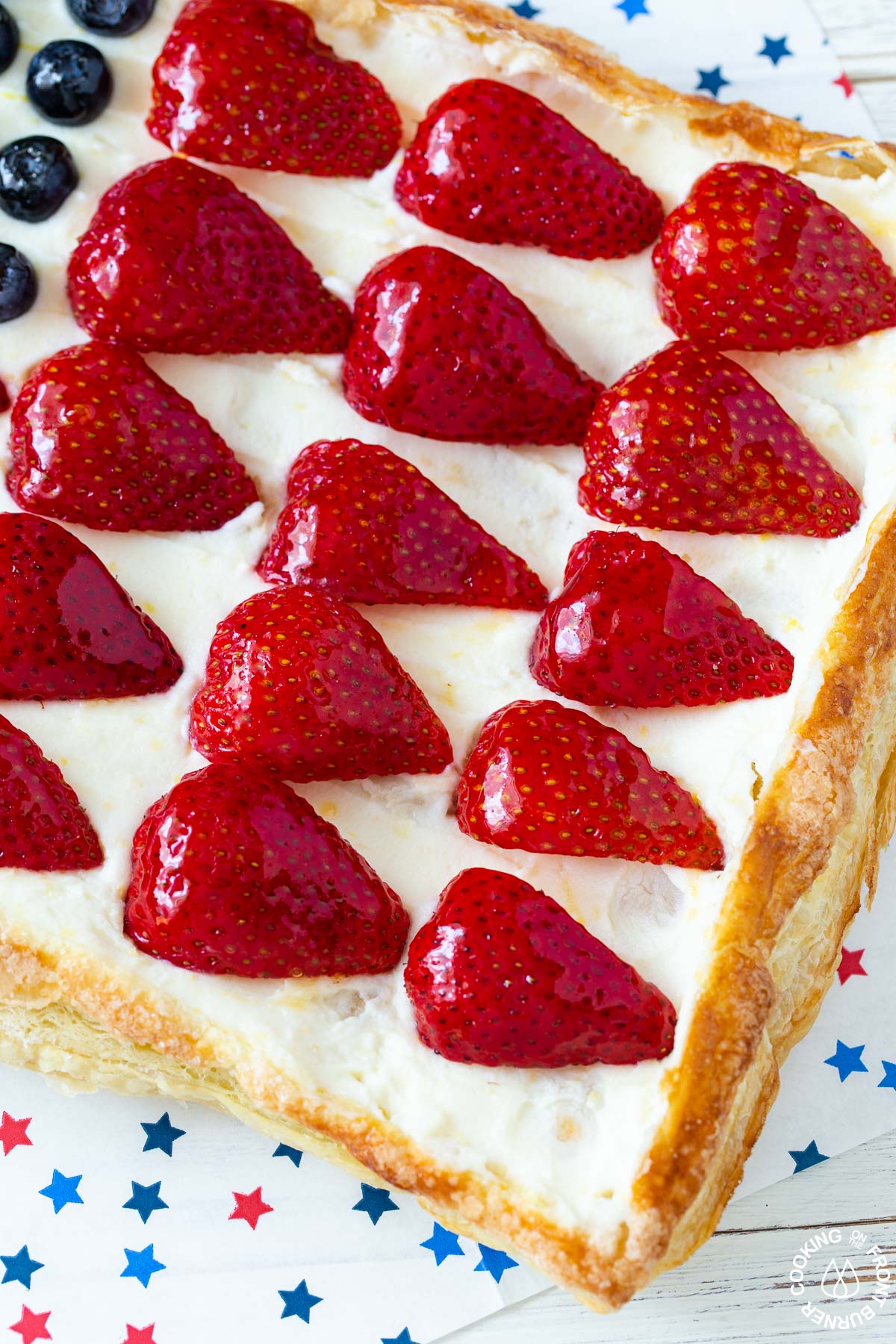 a close up picture of an american flag tart with glazed strawberries