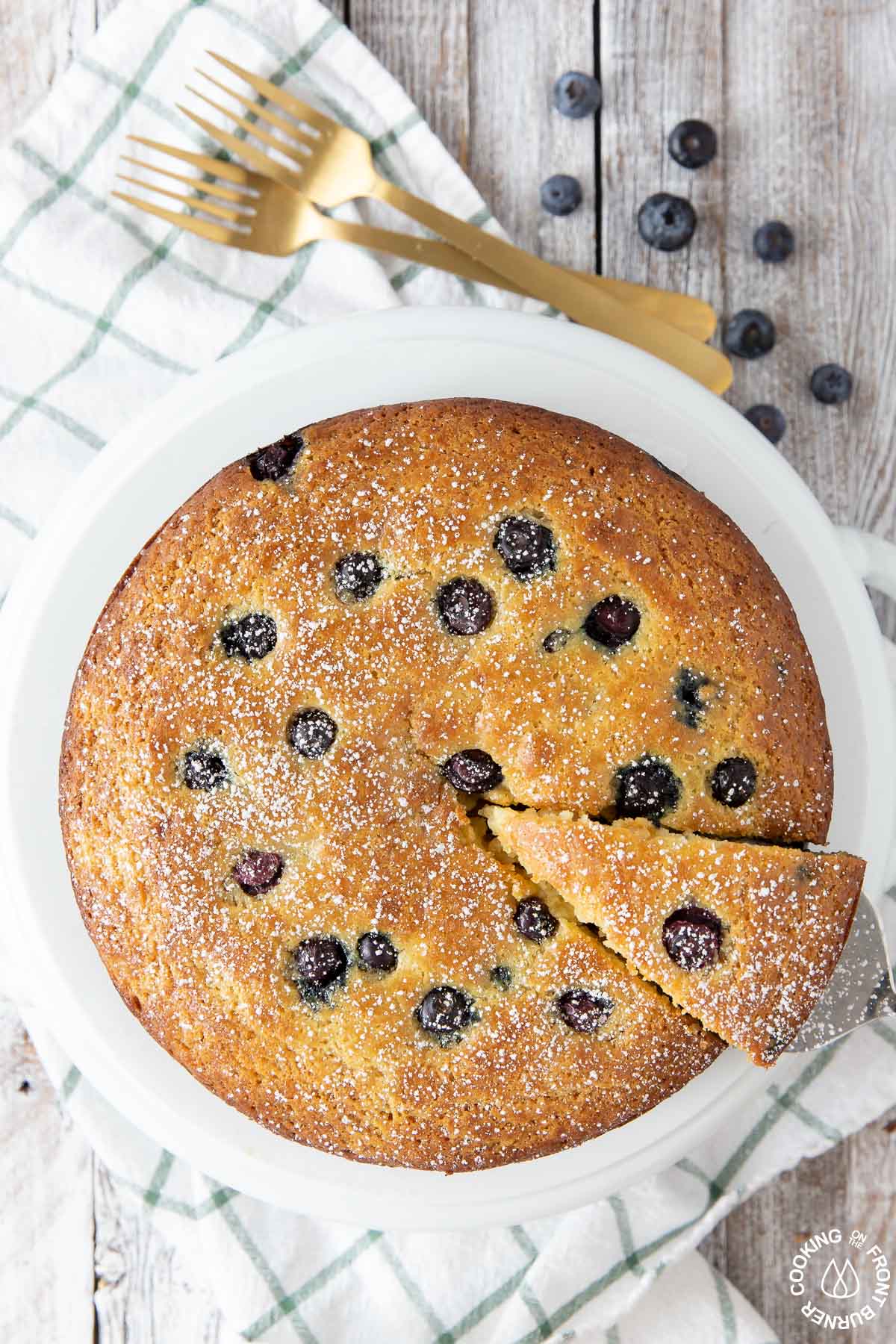 lemon blueberry ricotta cake on a plate with a slice cut out