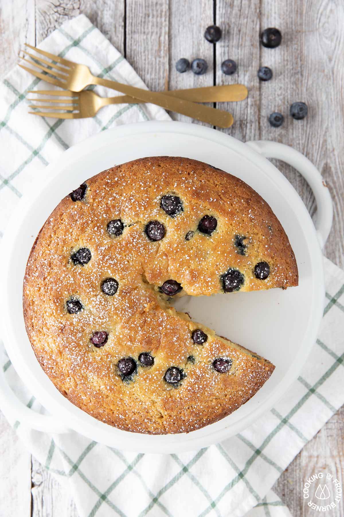 ricotta cake on a cake plate showing a slice missing