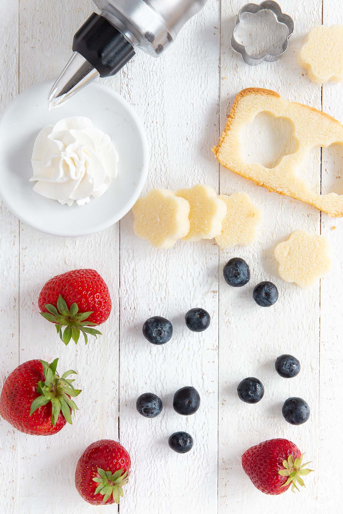 pound cake, cool whip, fresh strawberries and blueberries on a cutting board - overhead view