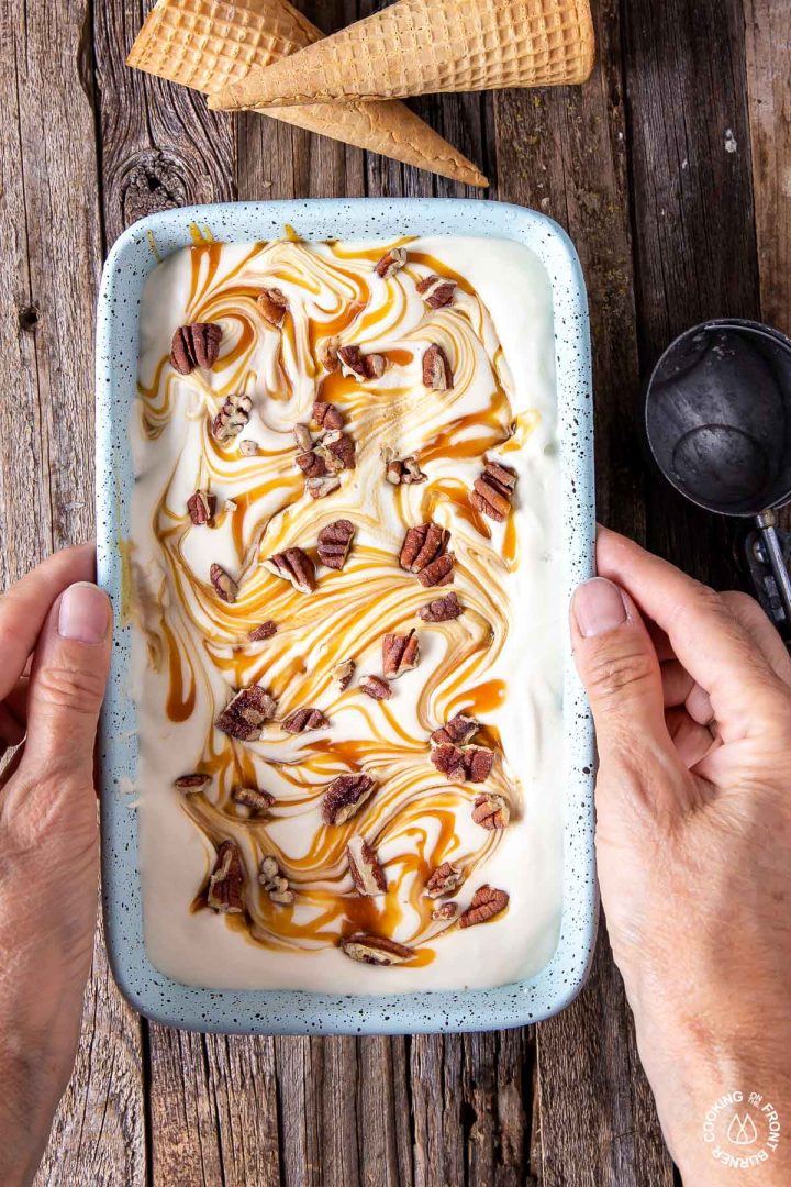 2 hands holding a loaf pan of frozen no churn ice cream