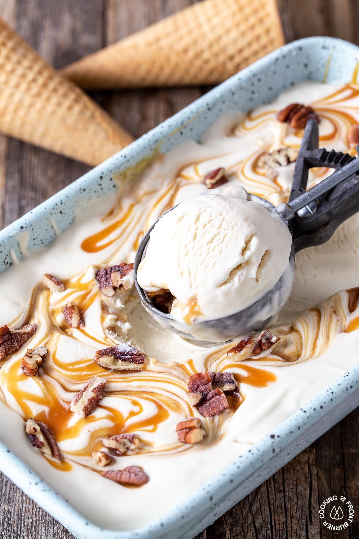 a loaf pan with bourbon pecan caramel ice cream with a scoop