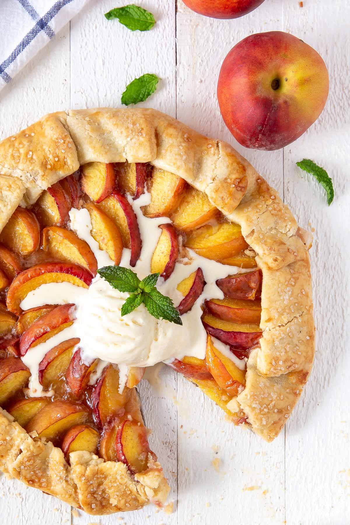 peach galette topped with vanilla ice cream with a slice cut out