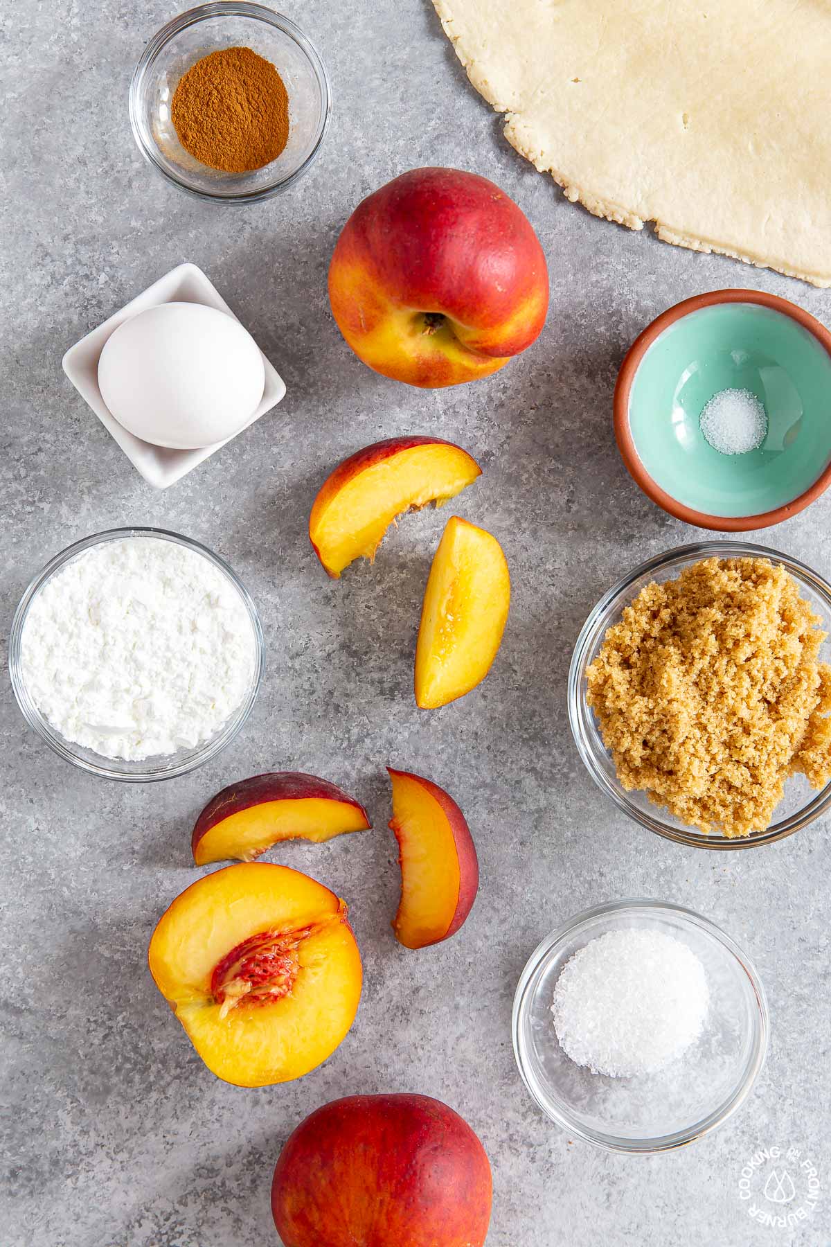 fresh peaches, grown sugar, cinnamon, egg, salt, cornstarch in bowls on a board