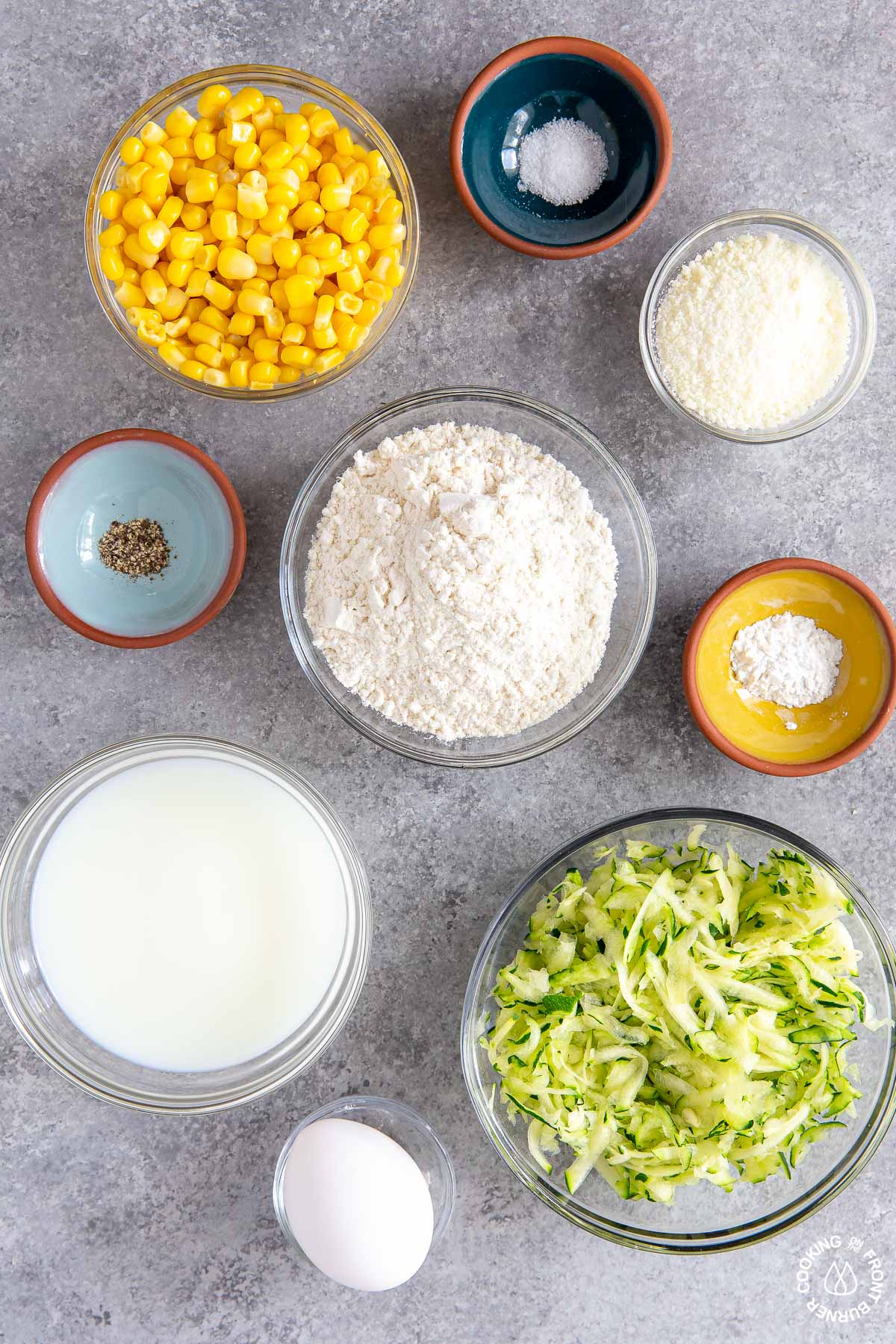 in bowls-corn, grated zucchini, cheese, salt, pepper, milk, flour, baking powder