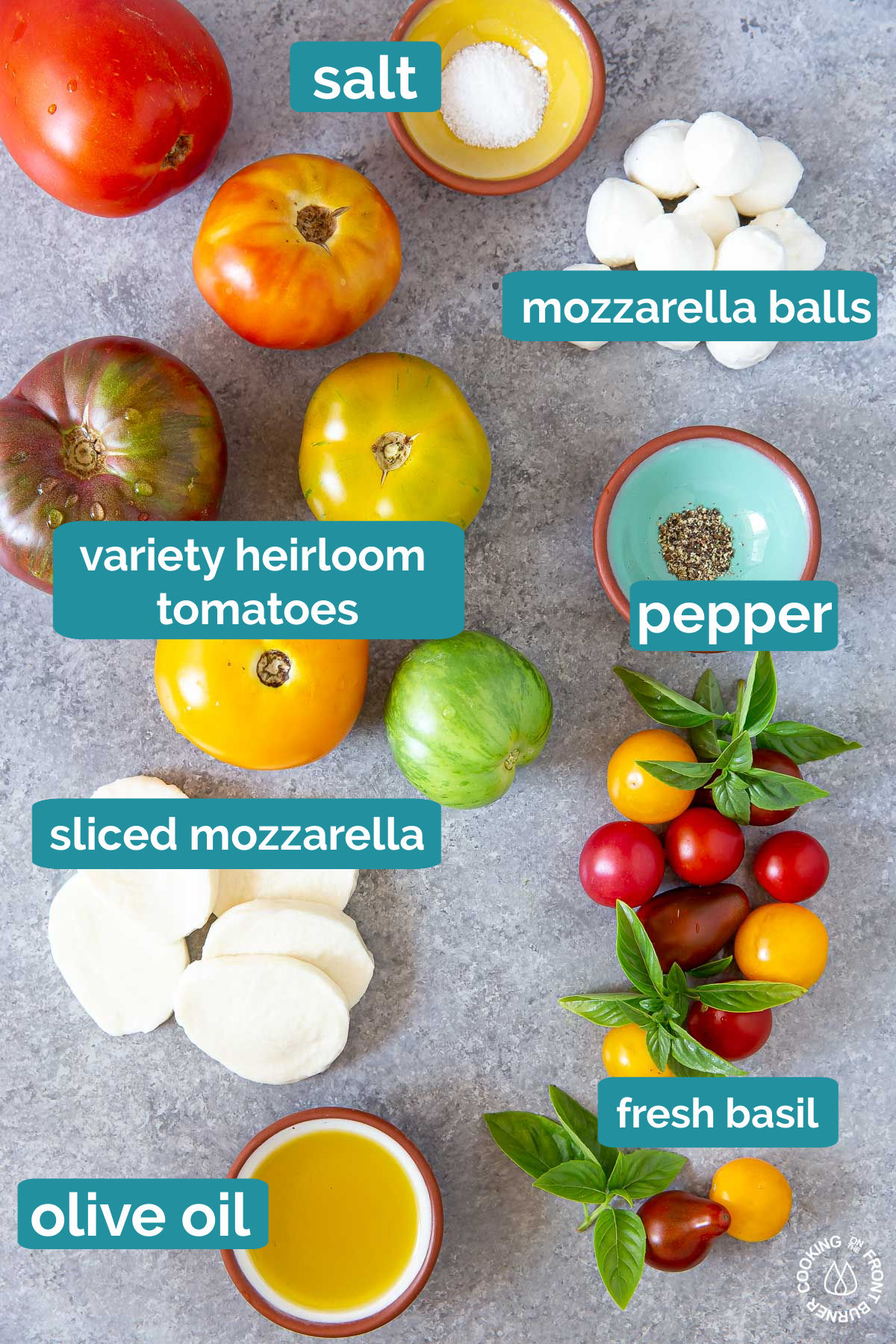 tomatoes, mozzarella cheese, salt, pepper, basil and olive oil in bowls on a grey board