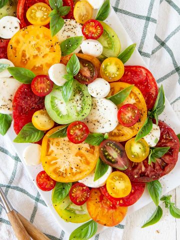 tomatoes, mozzarella, basil on a white plate