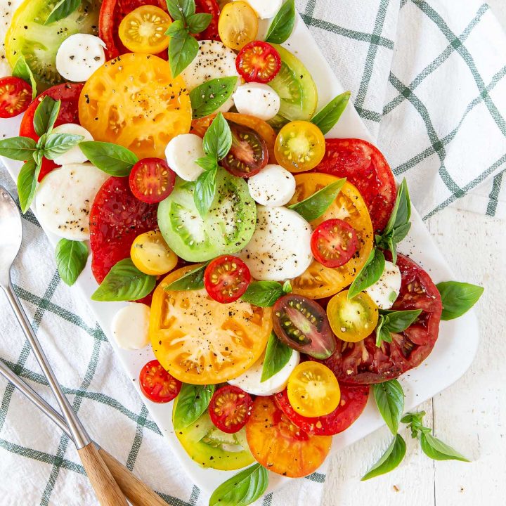 tomatoes, mozzarella, basil on a white plate