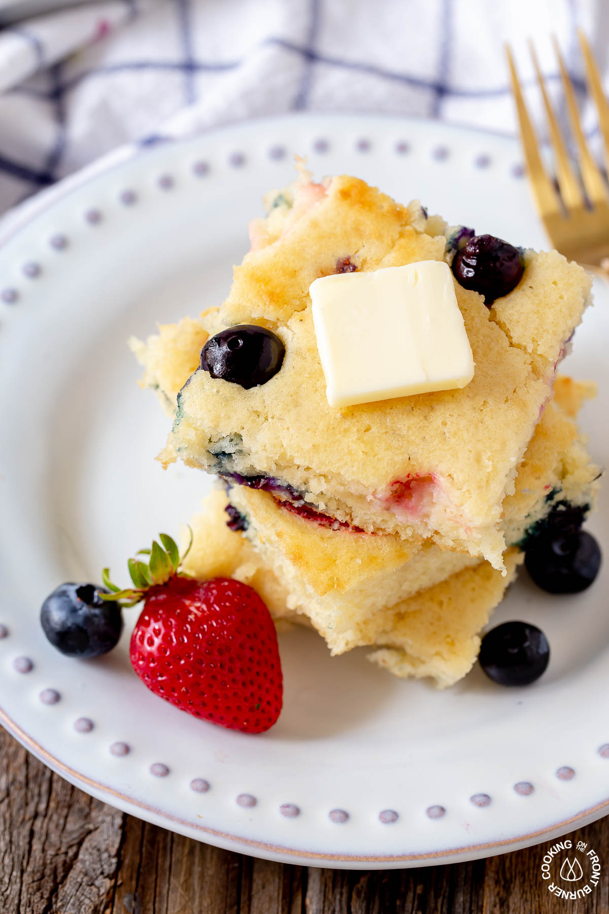 3 sheet pan pancake slices on a plate with a pat of butter on top