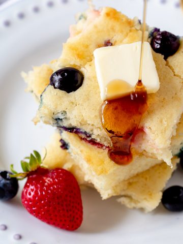 sheet pan pancakes being drizzled with maple syrup