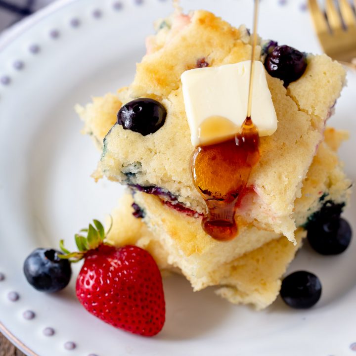 sheet pan pancakes being drizzled with maple syrup