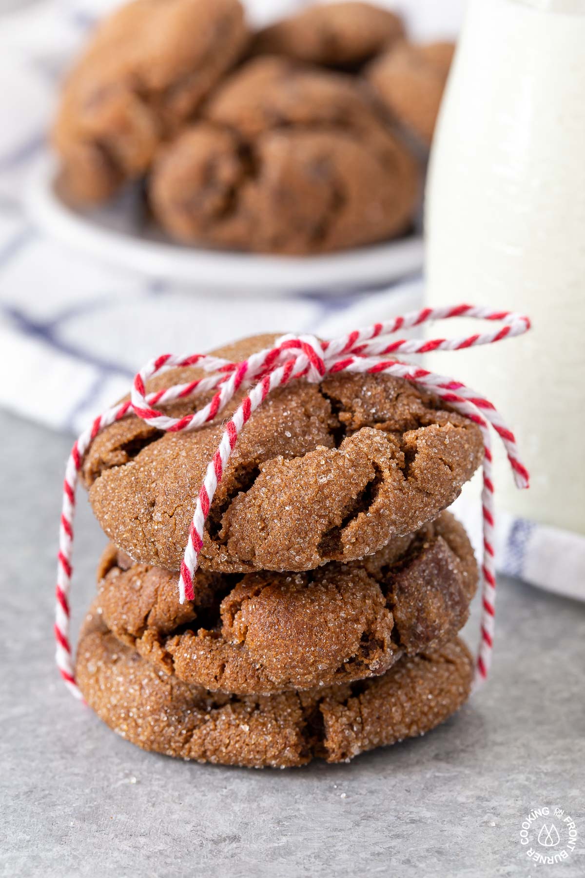 2 triple ginger cookies tied with a string by a small bottle of milk