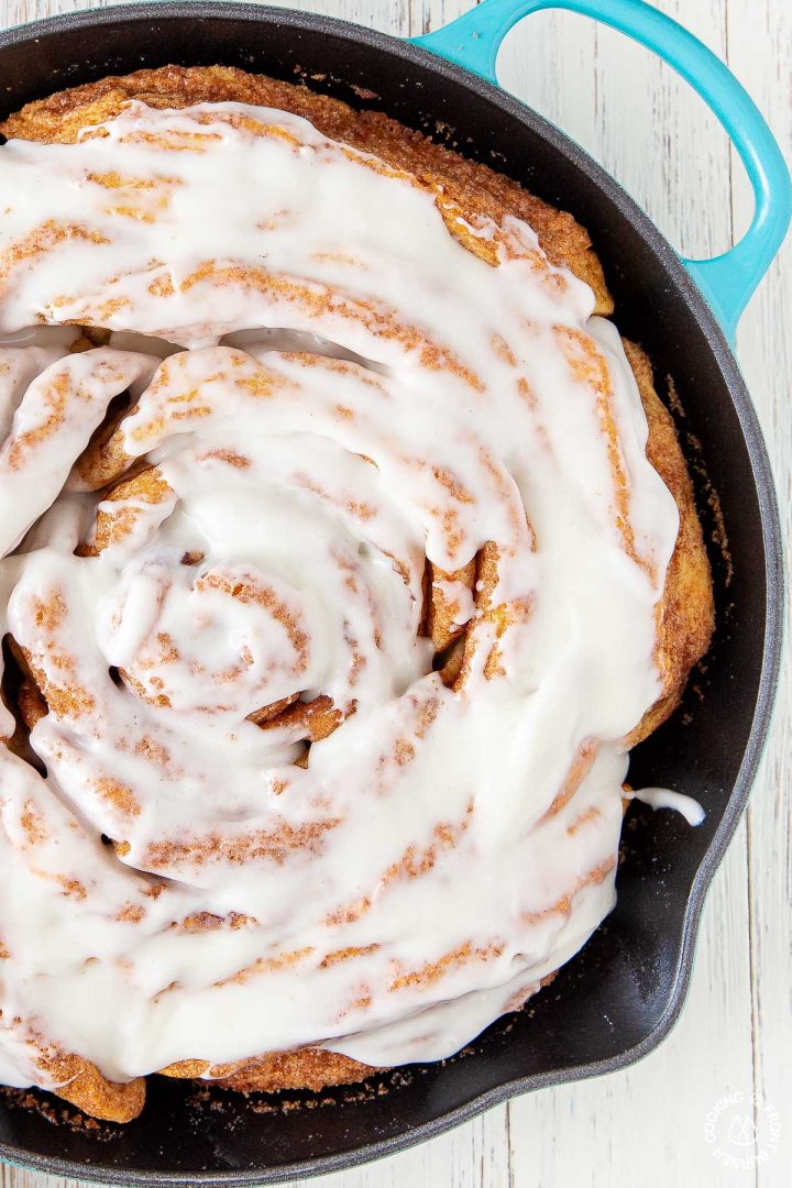 giant cinnamon roll in a turqouise skillet