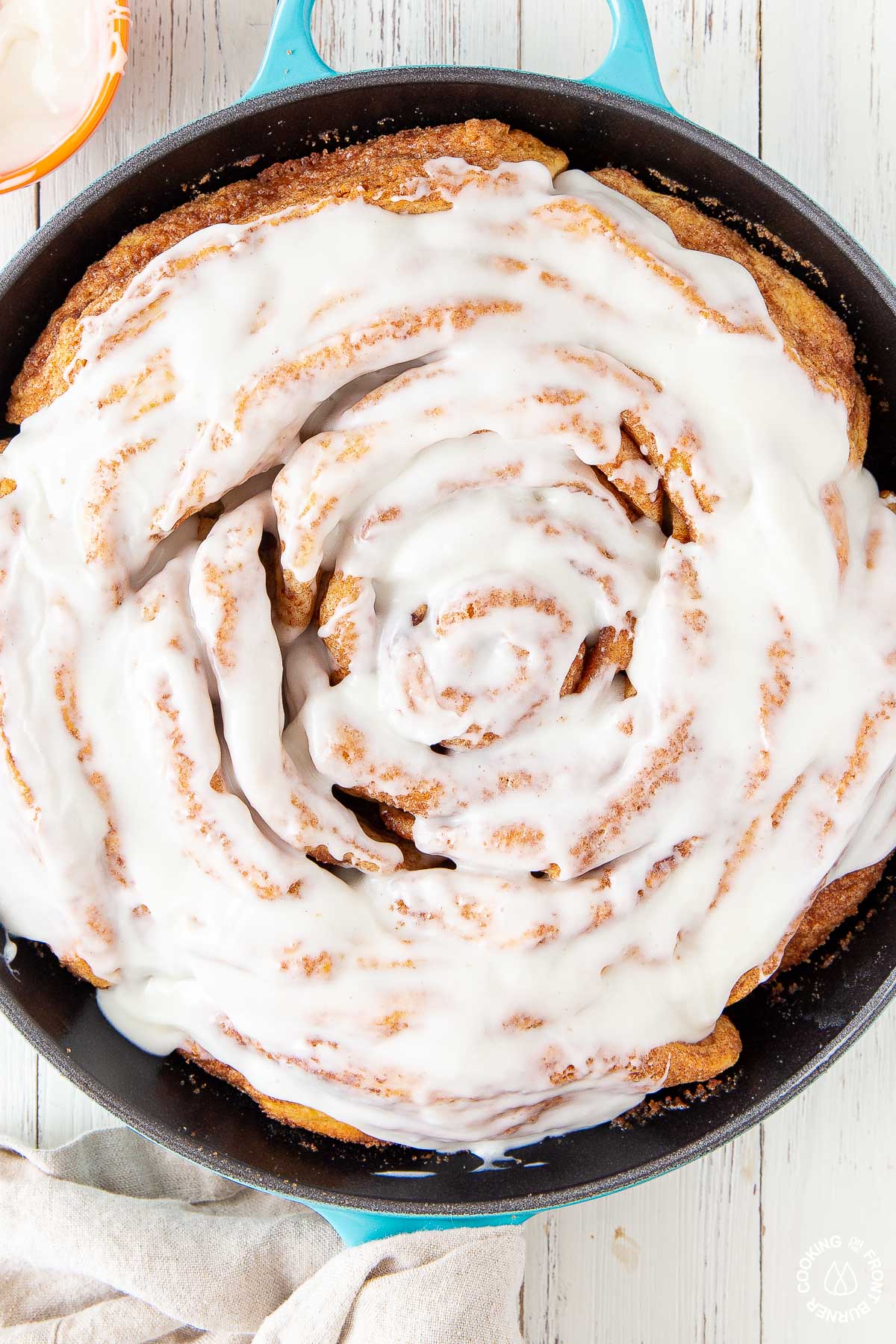 a close up picture giant cinnamon roll in a skillet