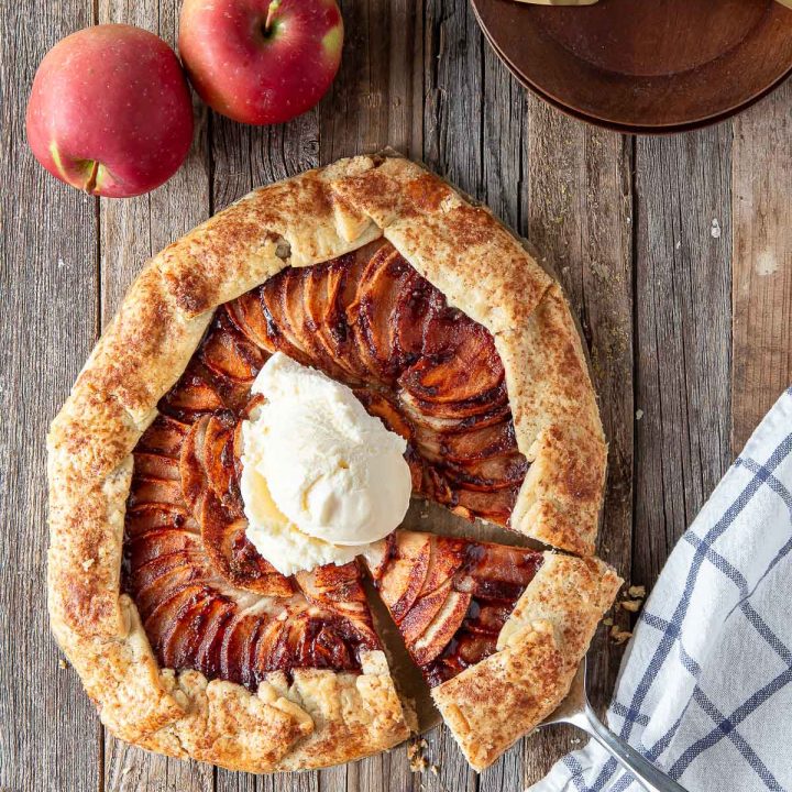 apple galette on a board topped with vanilla ice cream