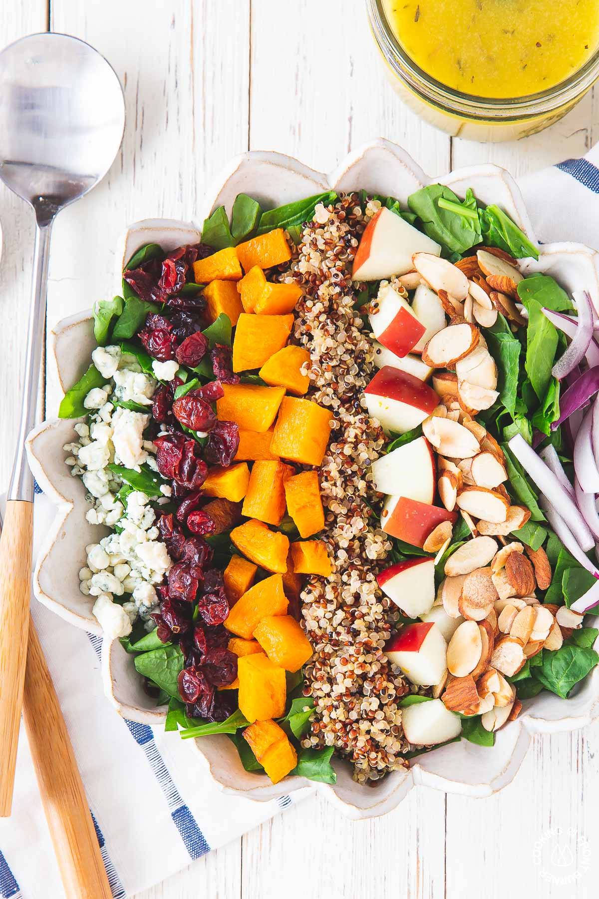 bowl with chopped spinach, red onions, butternut squash, apples, blue cheese, quinoa