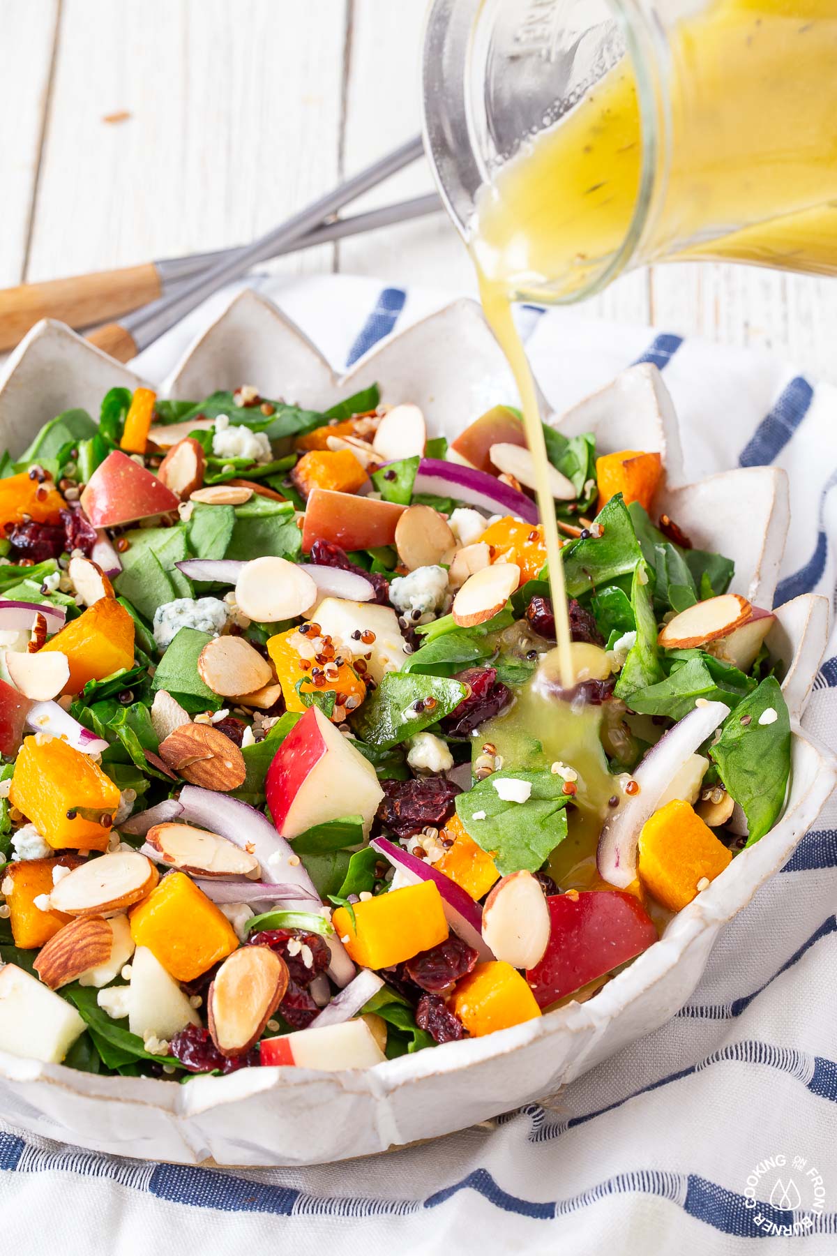 drizzling maple vinaigrette over a chopped fall salad