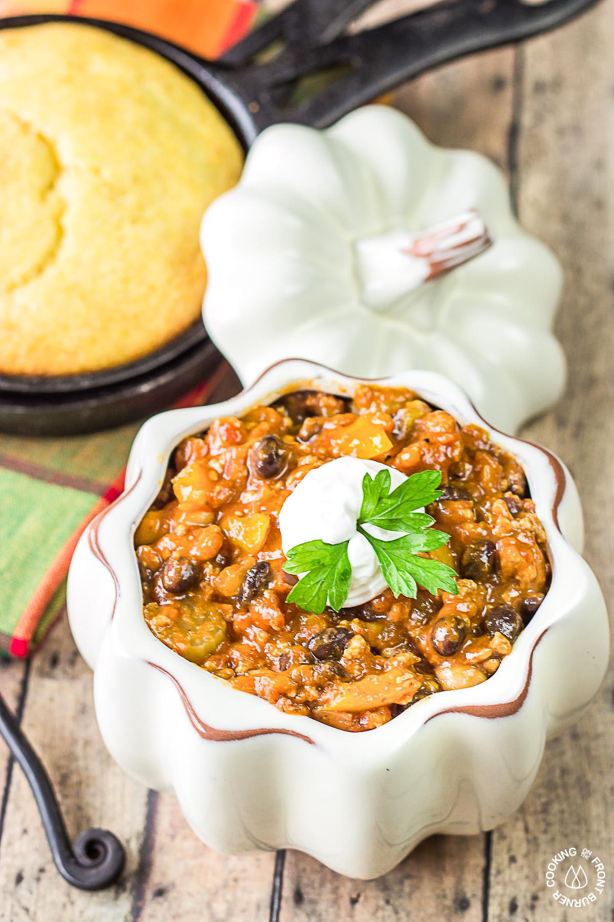 turkey pumpkin chili in a white bowl with a side of corn bread