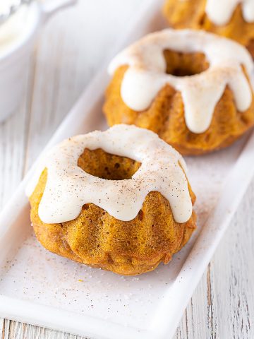 two mini pumpkin spice bundt cakes on a white plate