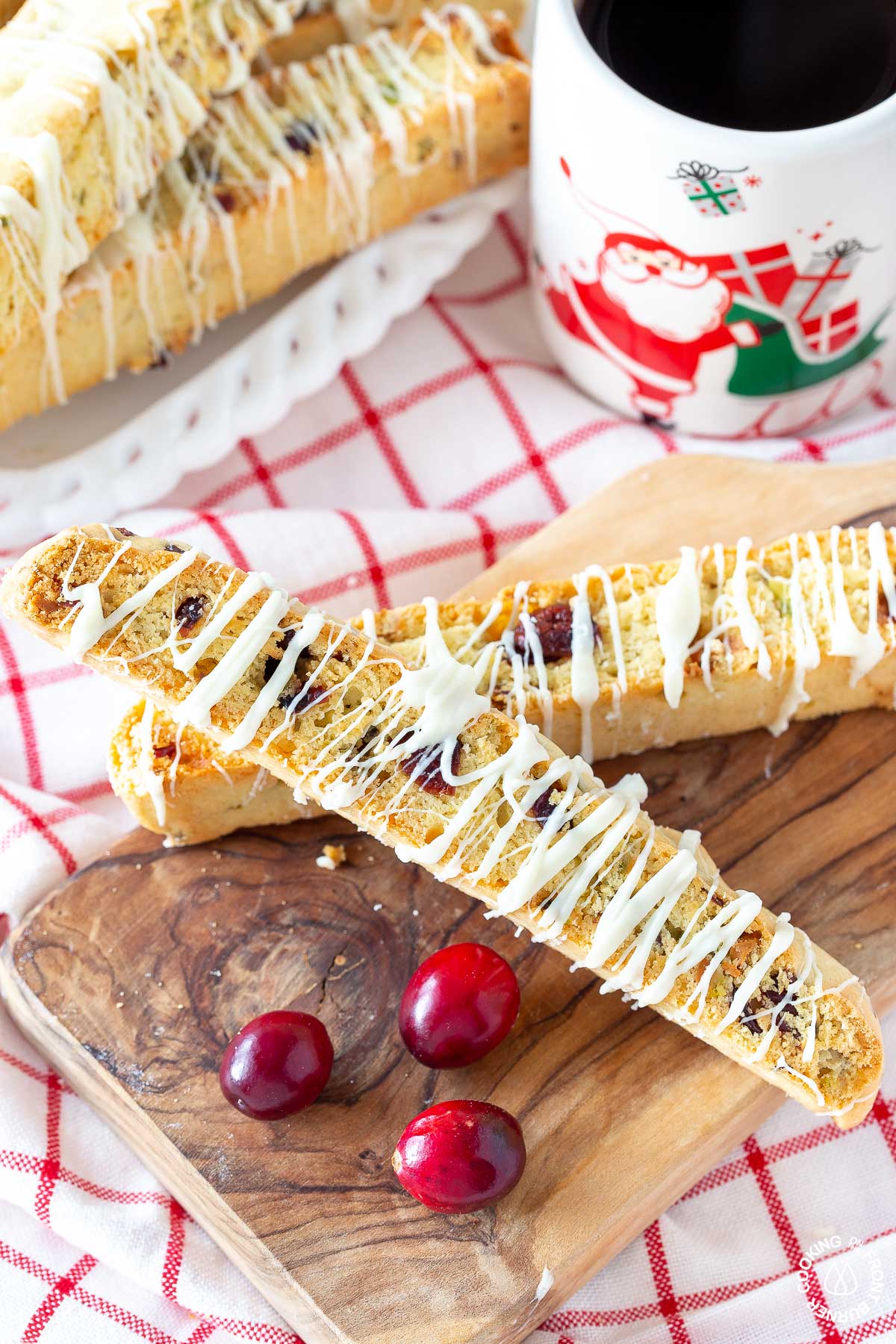 two cranberry pistachio biscotti on a small cutting board