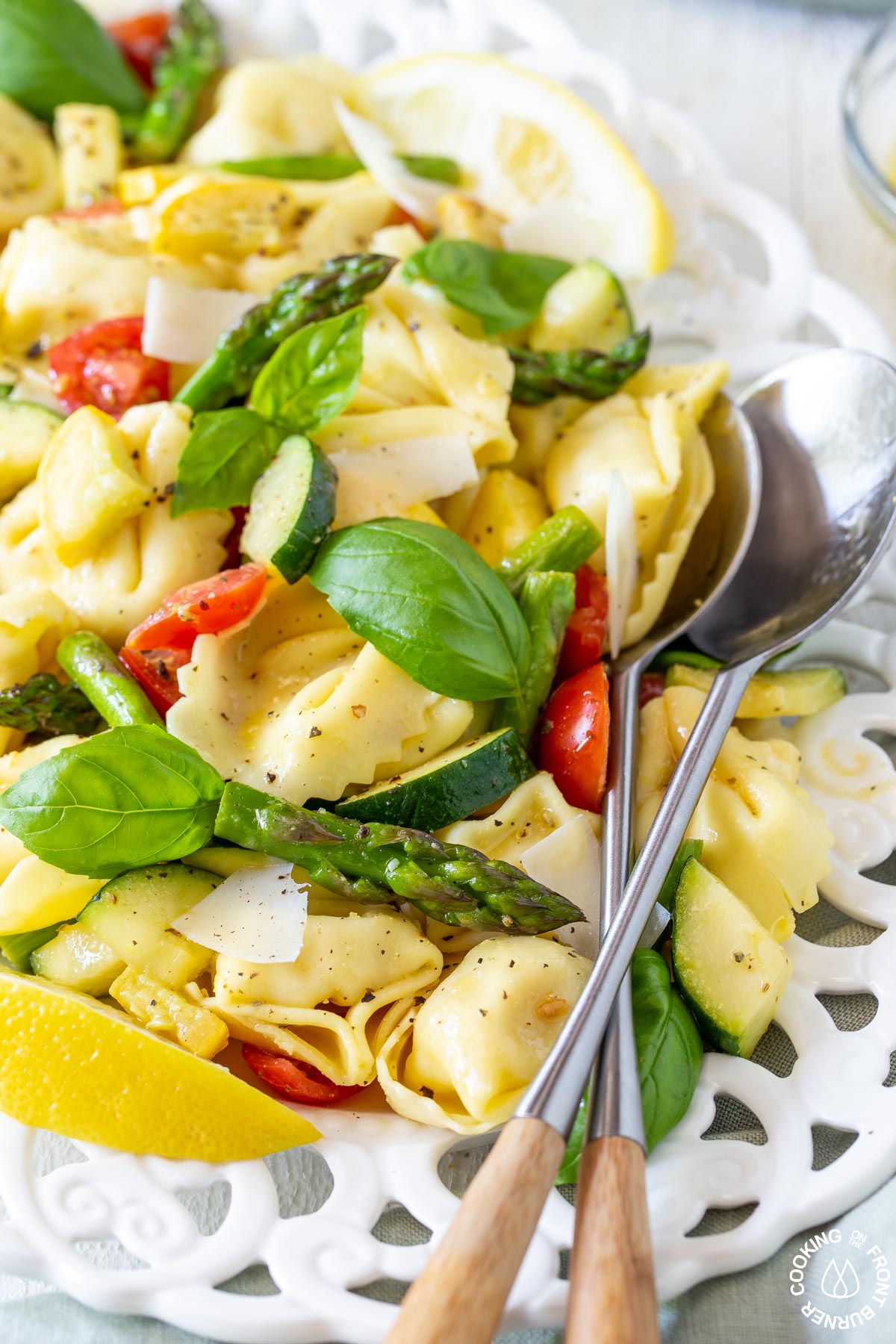 a plate with tortellini, squash, basil and asparagus