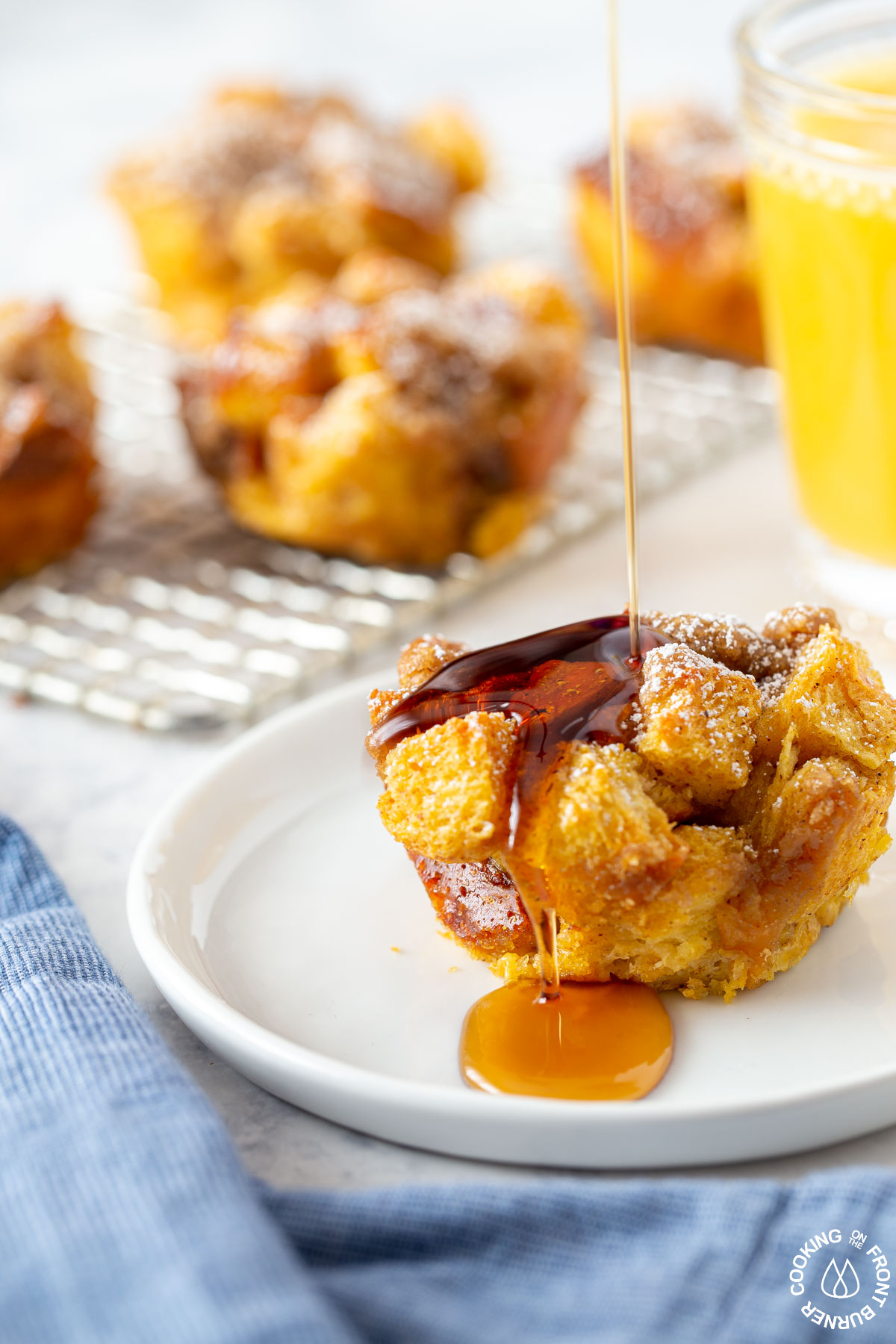 pumpkin butter french toast muffin on white plate drizzle maple syrup