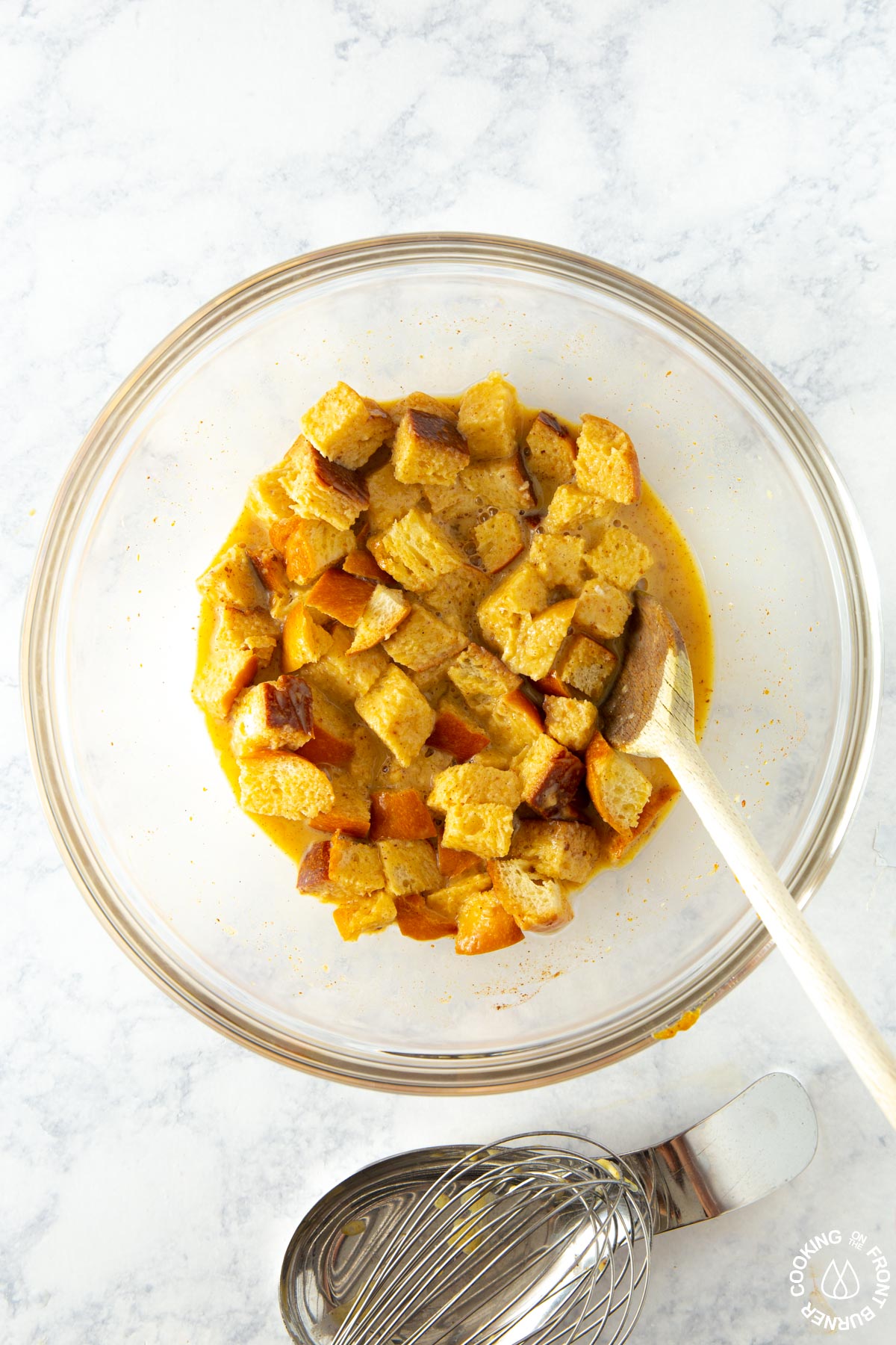 adding cubed bread to a pumpkin milk mixture