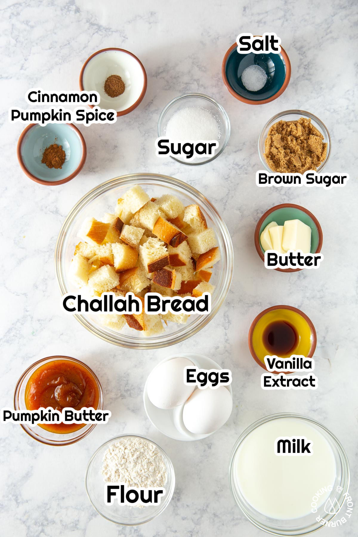 flour, sugar, vanilla, bread cubes, sugar,eggs in bowls on a board