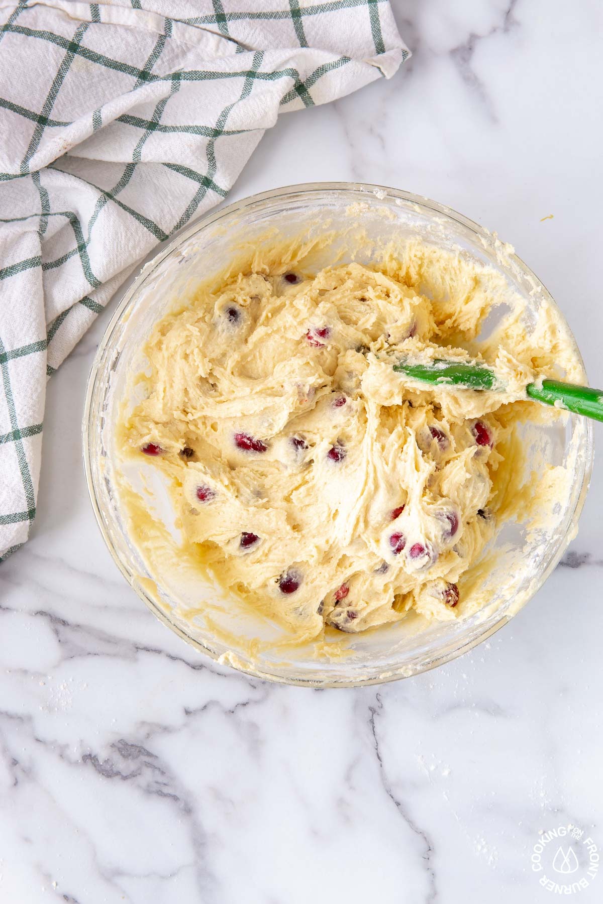 a clear bowl; mixture of cranberries and batter